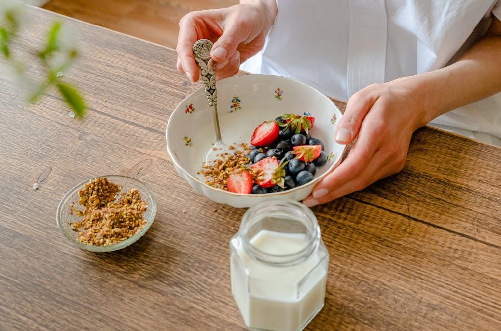 A vibrant homemade yogurt bowl with strawberries, blueberries, and crushed nuts, perfect for a healthy breakfast.