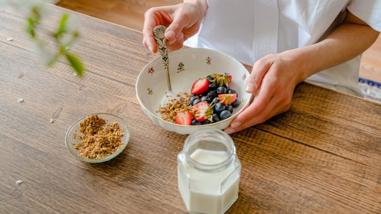 A vibrant homemade yogurt bowl with strawberries, blueberries, and crushed nuts, perfect for a healthy breakfast.
