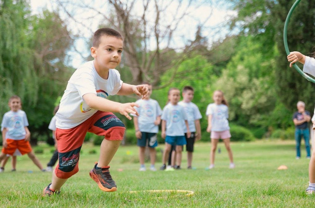 A group of children actively playing with hula hoops on a bright summer day in the park.